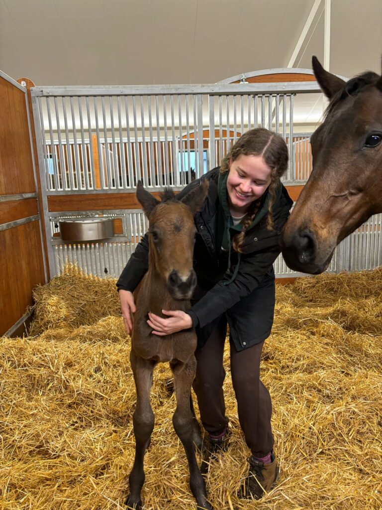 2024 Student Annie Holland with the first foal she helped deliver during her placement at Cambridge Stud New Zealand.